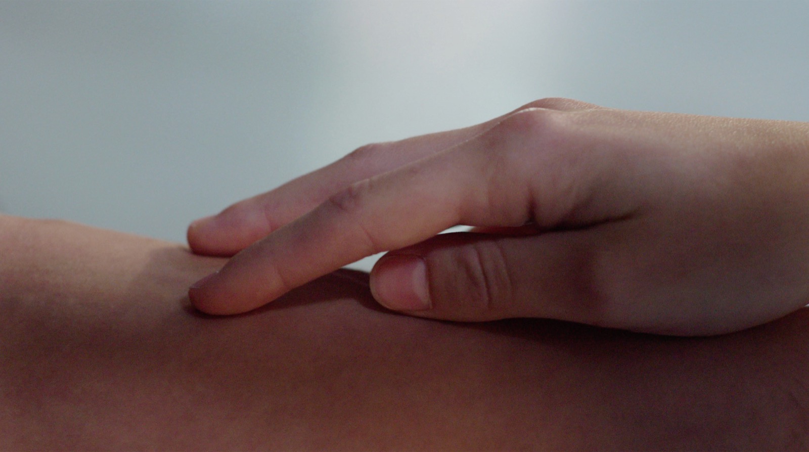 A hand resting gently on an arm